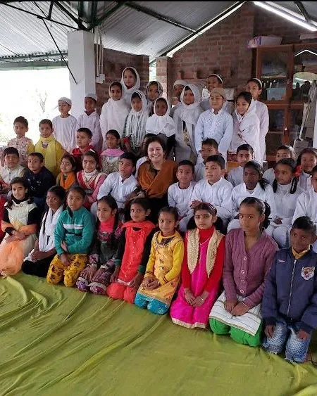 Shefali Chopra seated with a hall full of schoolchildren
