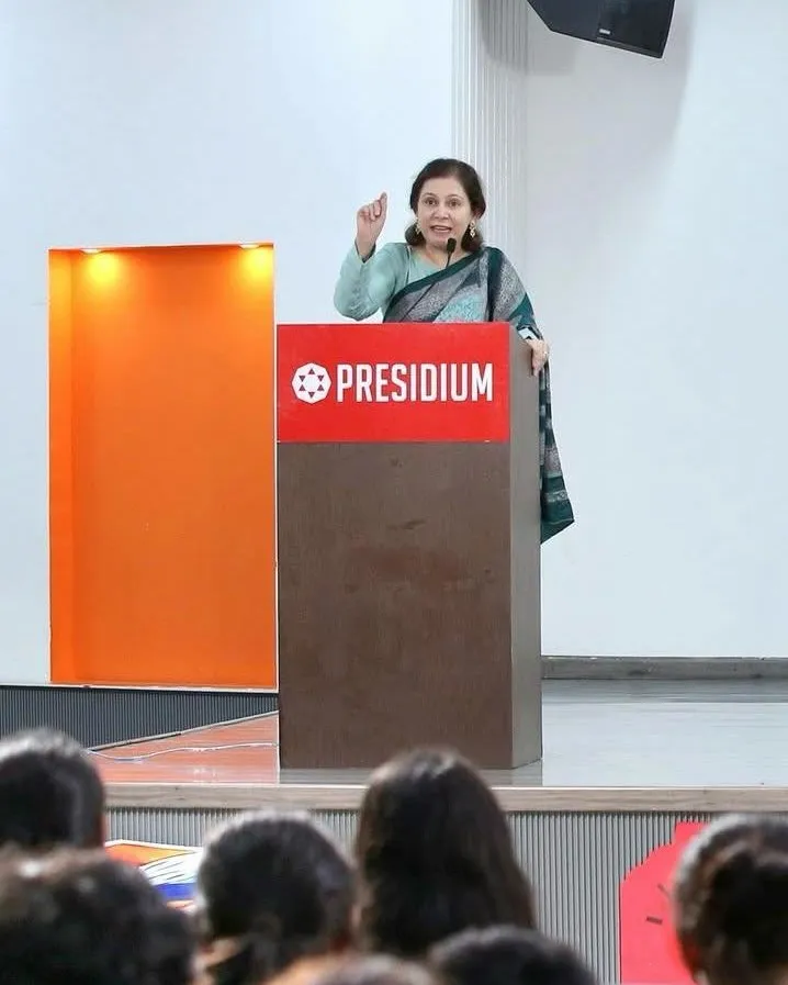 Shefali Chopra speaking at a podium to a seated student audience